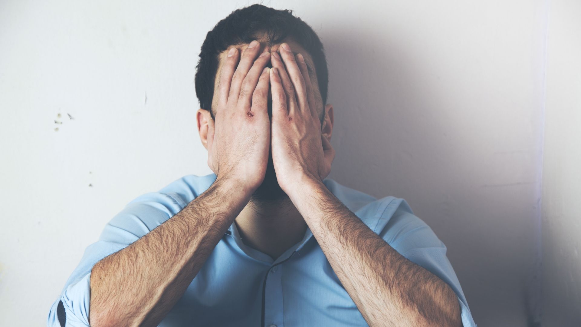 man holding his face in his hands